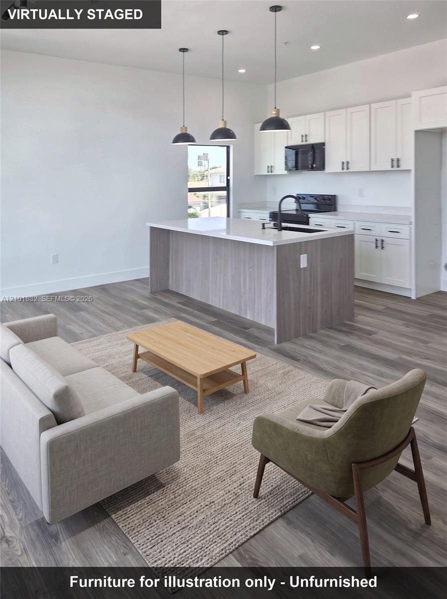 Kitchen featuring white upper cabinetry, a wood-finish island, solid surface countertops, recessed lighting, and three pendant lights