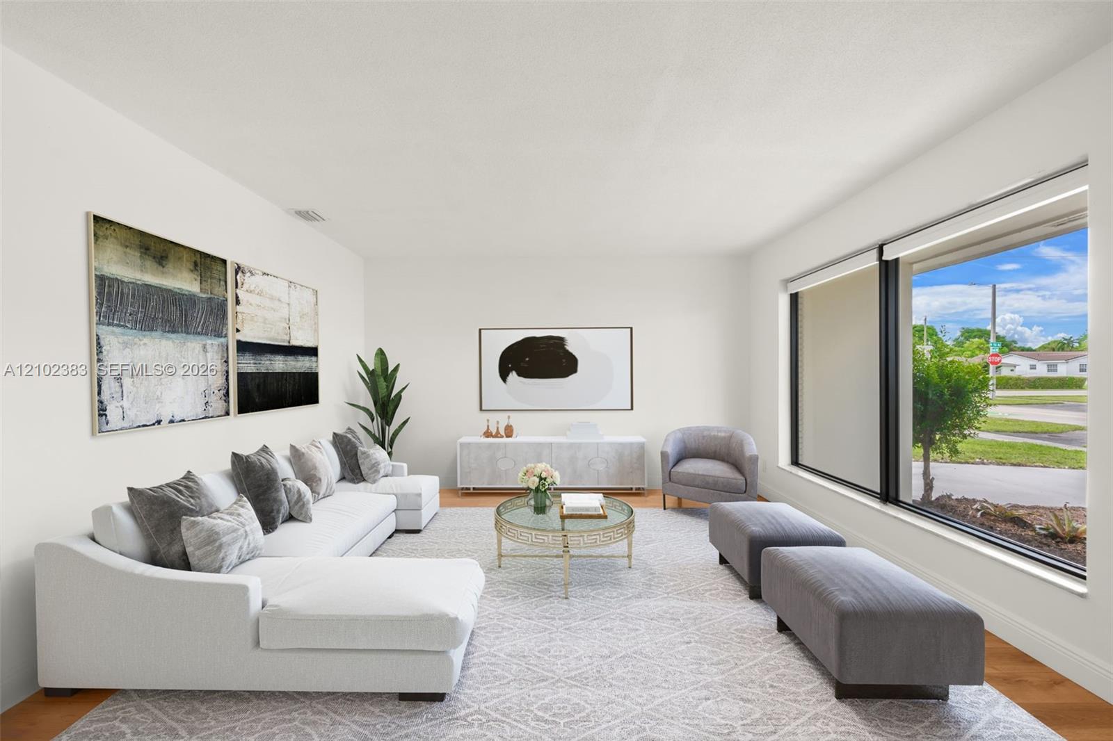 Living area featuring large windows with black frames and wood-finish flooring