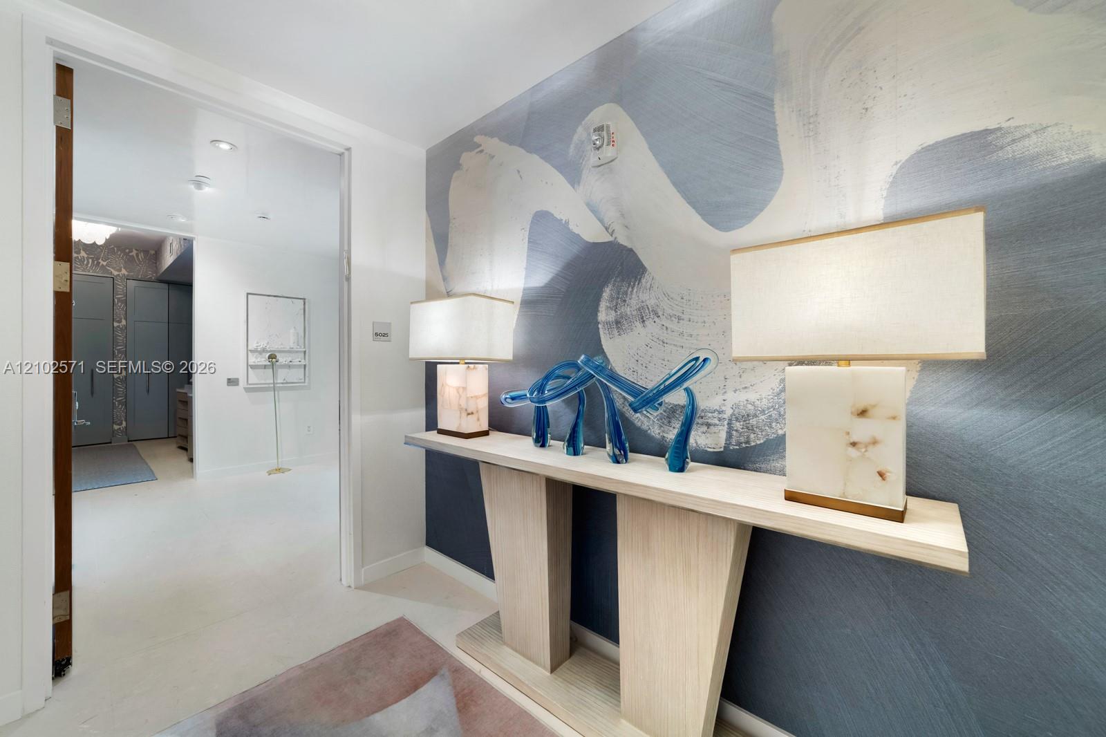 Wall-mounted console table with a minimalist aesthetic and integrated large-format feature wall mural