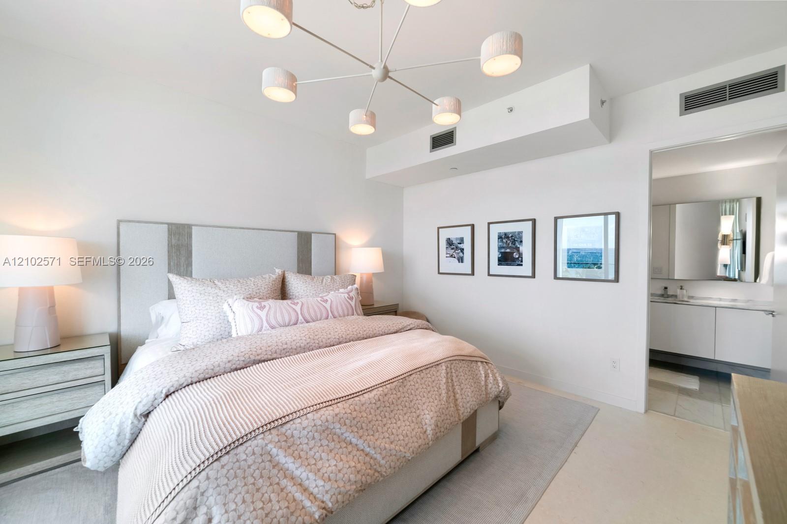 Modern chandelier with multiple drum shades, recessed ceiling lighting, and crisp neutral wall finishes
