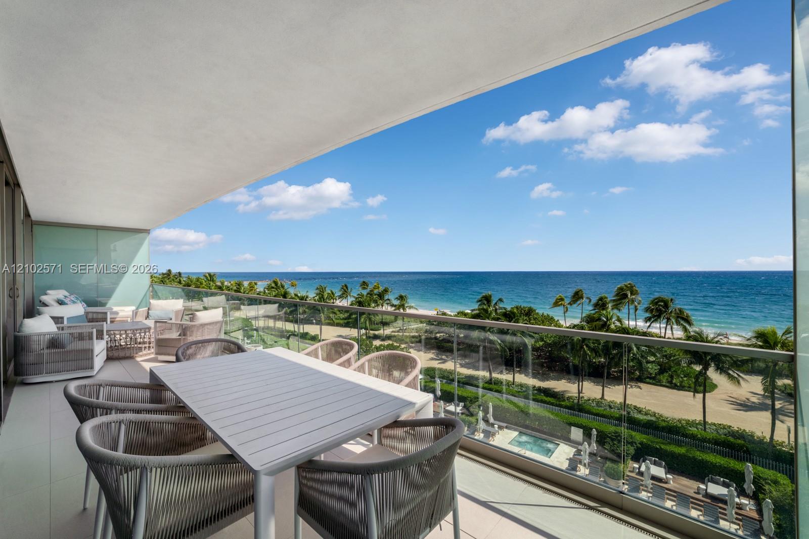 Covered balcony featuring glass railing panels and tile flooring