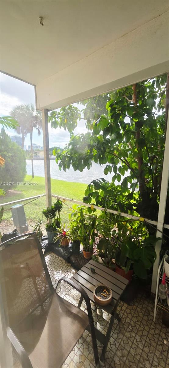 Screened-in porch featuring tile flooring and water frontage