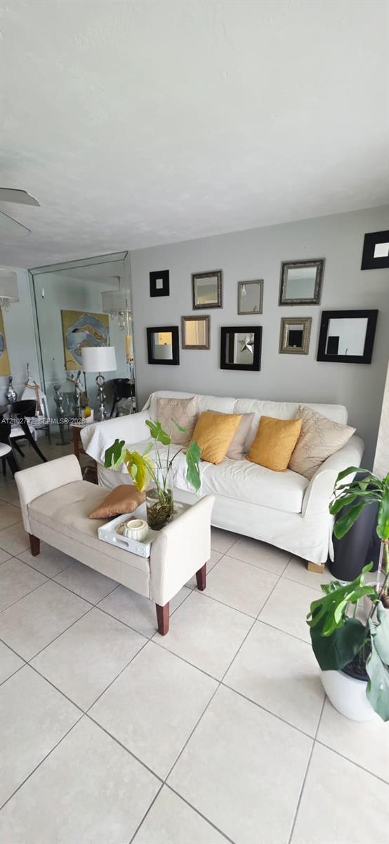 Living area featuring large-format ceramic tile flooring and a full-height mirrored wall panel