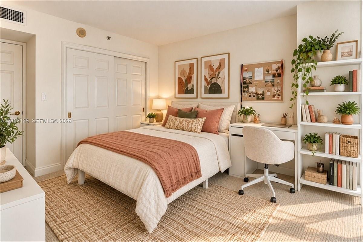 Neutral-toned carpeting, built-in shelving, and dual sliding closet doors with recessed handles