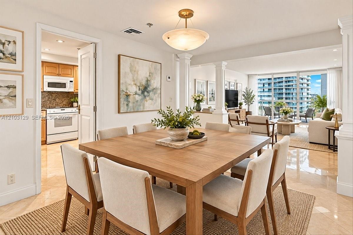 Open-concept interior featuring polished stone flooring, recessed architectural columns, and expansive floor-to-ceiling glass paneling