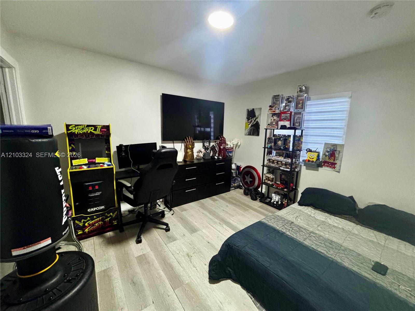 Room featuring neutral-toned walls, wood-finish flooring, and horizontal window blinds
