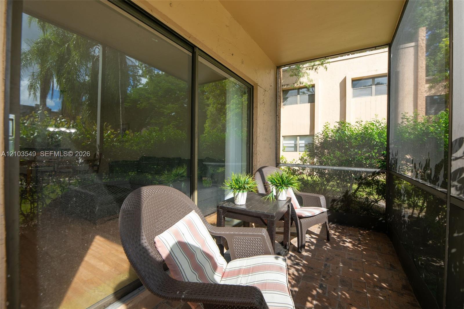 Screened-in porch featuring brick paver flooring, sliding glass doors, and structured metal framing