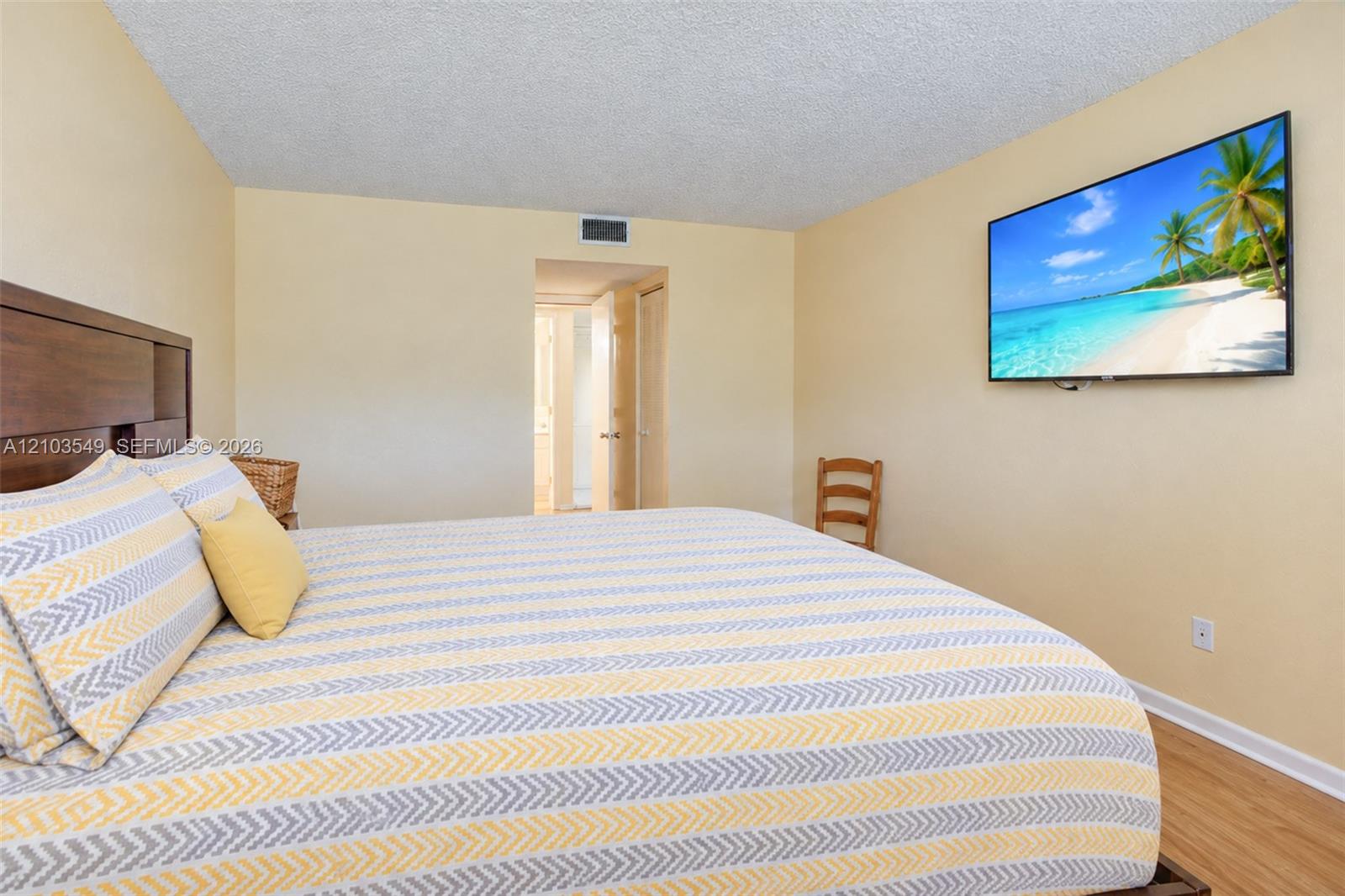 Neutral wall-to-wall interior paint, wood-finish flooring, and recessed ceiling texture