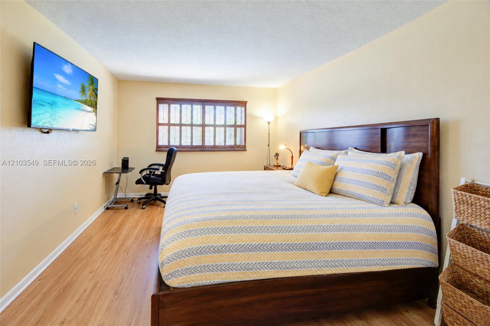 Wood-finish flooring, multi-pane window with dark-toned frame, and wall-mounted television hardware
