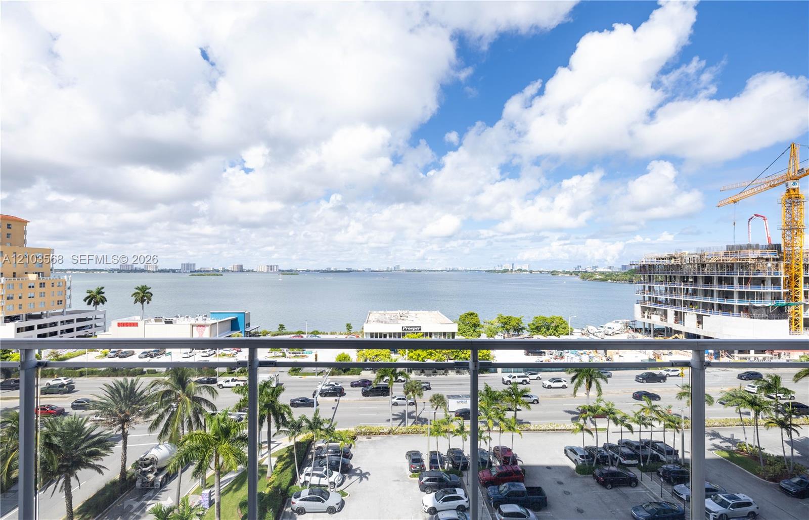 Elevated balcony featuring a glass and metal railing overlooking expansive water scenery and coastal landscape