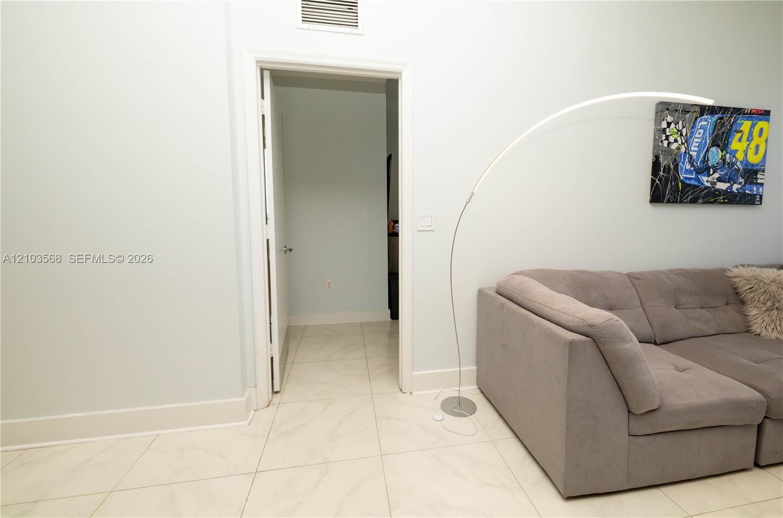 Interior space featuring large-format light-toned tile flooring and neutral wall color