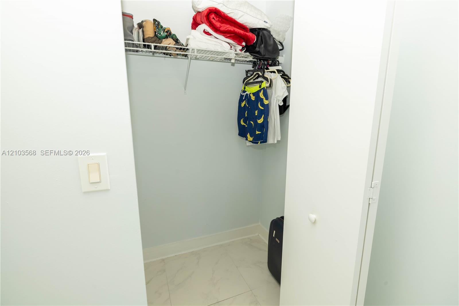 Storage closet featuring wire shelving and stone-finish floor tiling