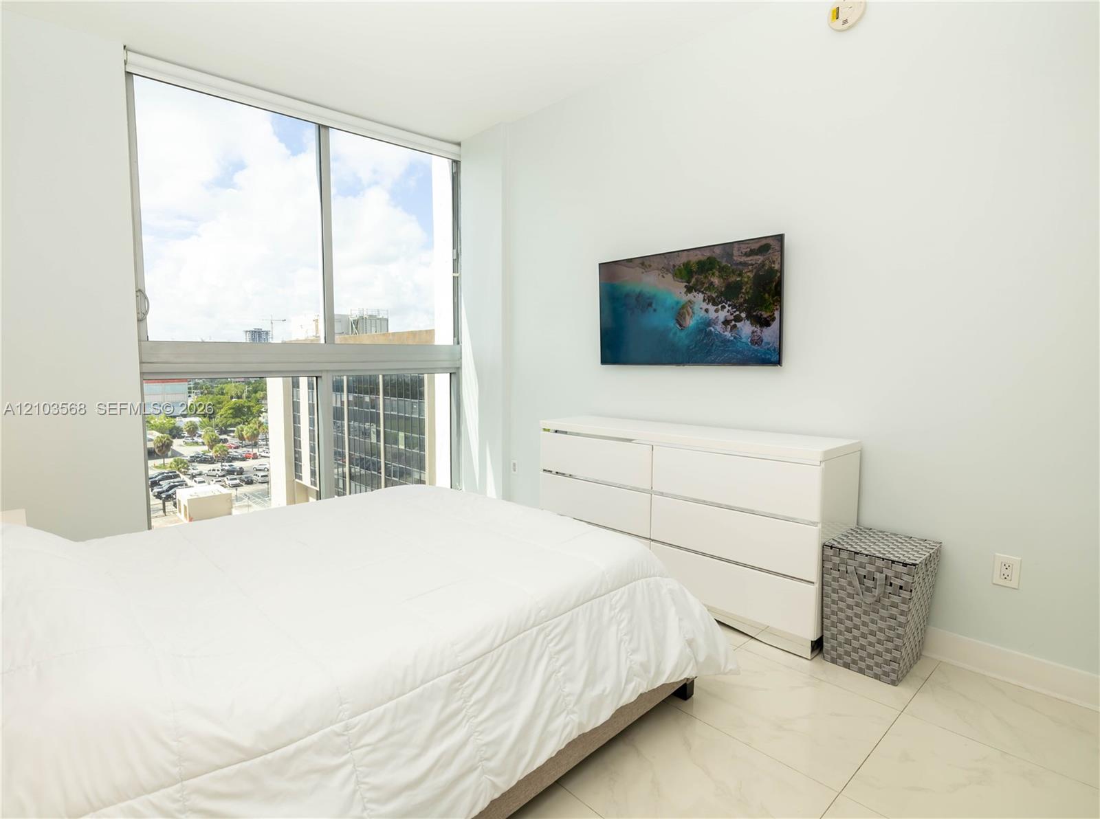 Floor-to-ceiling windows featuring urban scenery and large-format porcelain tile flooring