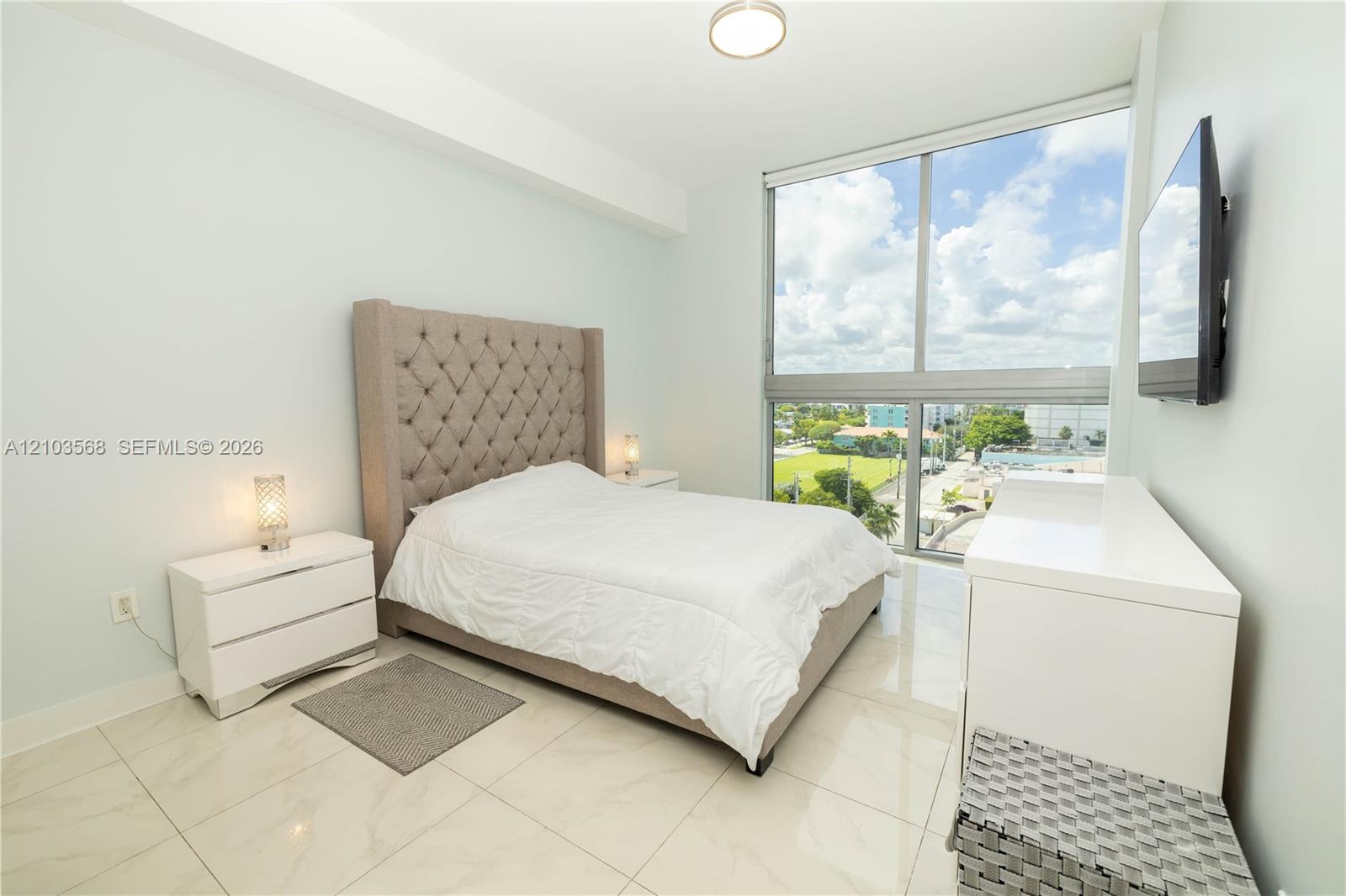 Floor-to-ceiling windows, polished light-toned tile flooring, and flush-mount ceiling lighting