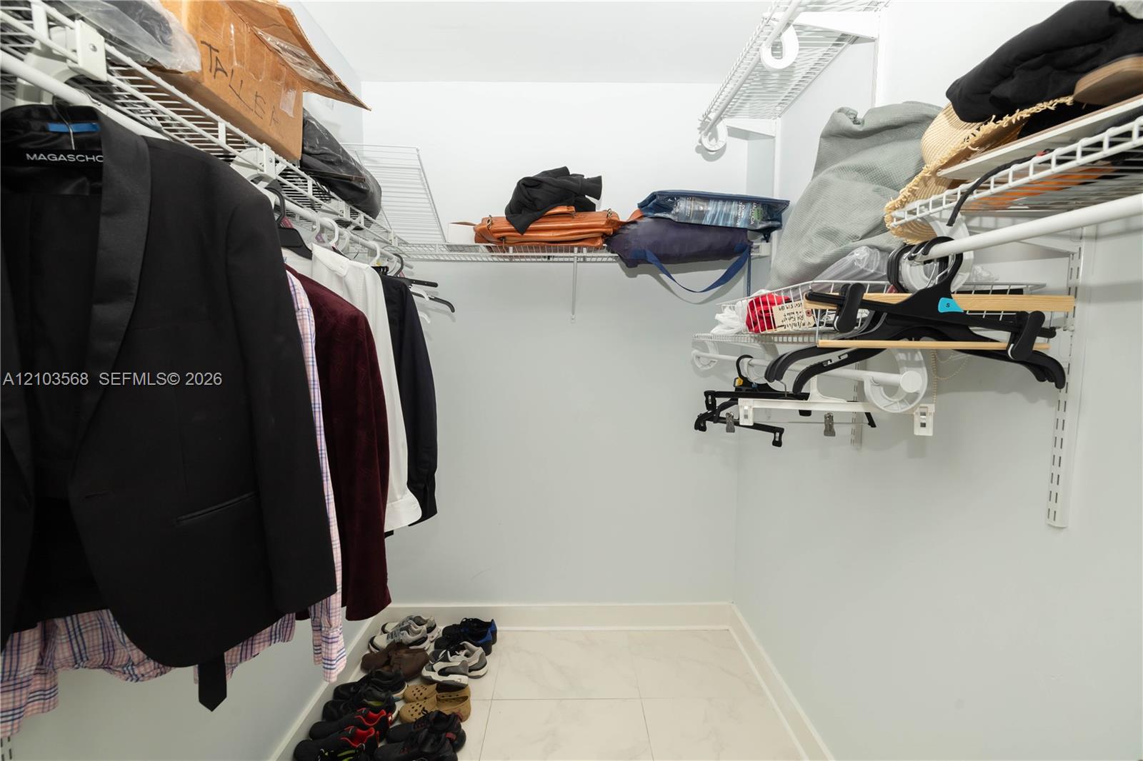 Walk-in closet featuring floor-to-ceiling white wire shelving and light-colored tile flooring