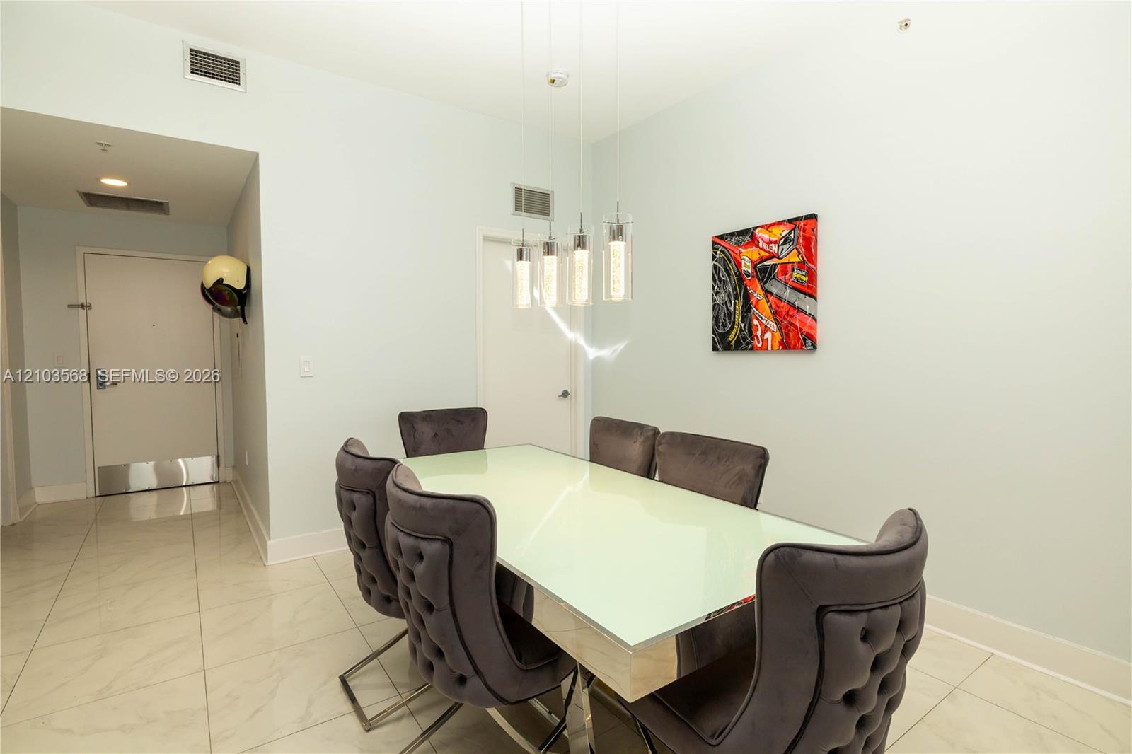 Light-toned tile flooring, four-pendant glass light fixture, and neutral wall palette