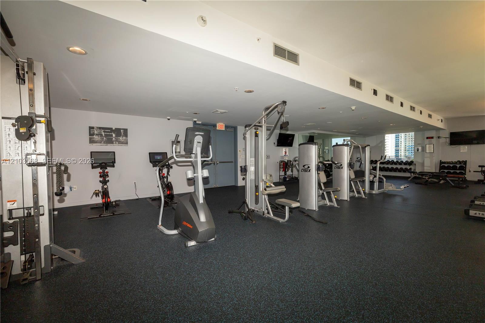 Fitness center featuring industrial-grade exercise equipment, rubberized flooring, and recessed ceiling lighting