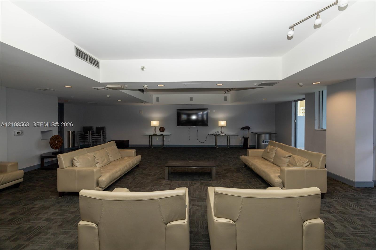Open-concept interior featuring recessed lighting, track lighting fixtures, and neutral carpet flooring