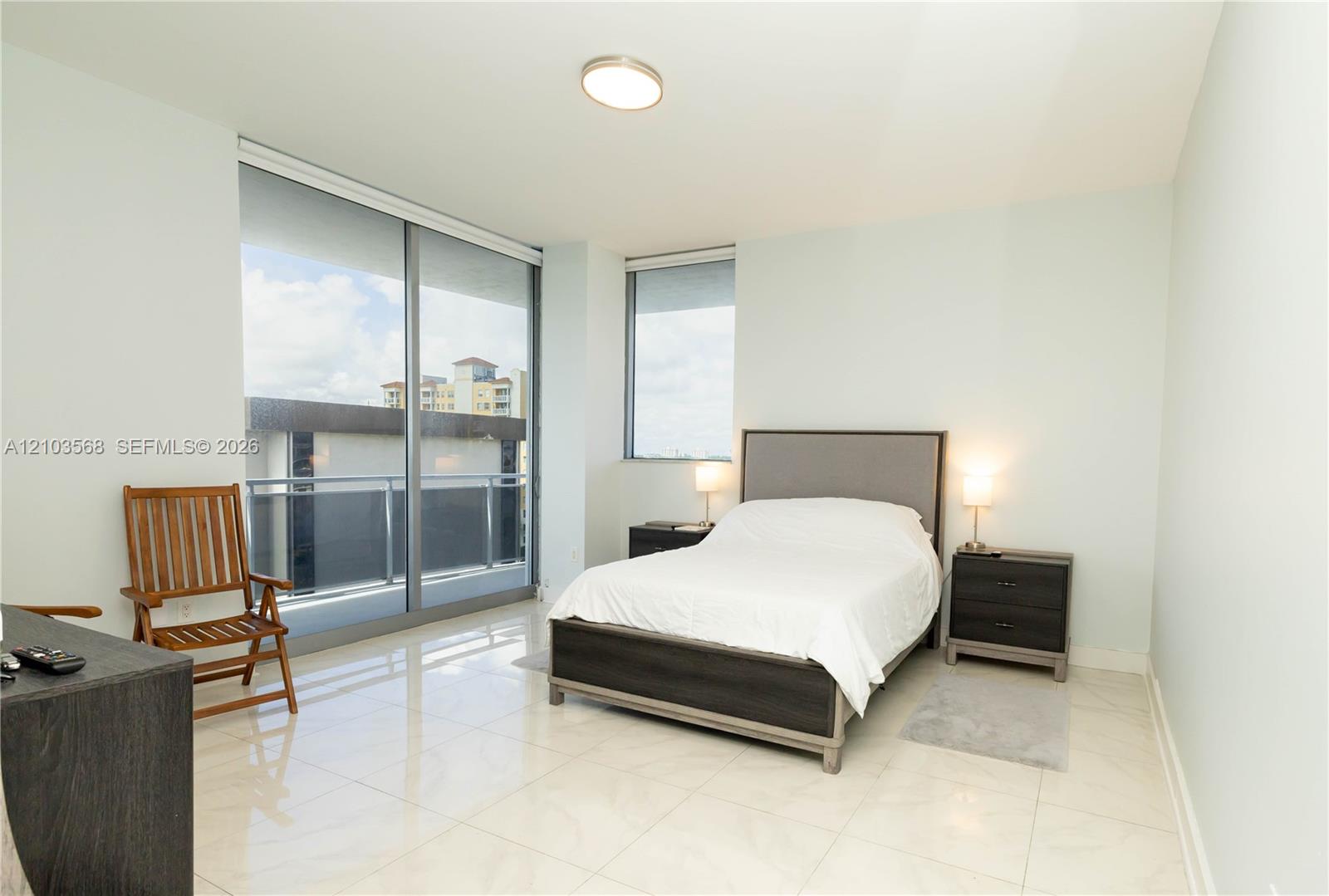 Floor-to-ceiling sliding glass doors, polished stone-finish flooring, and recessed ceiling lighting