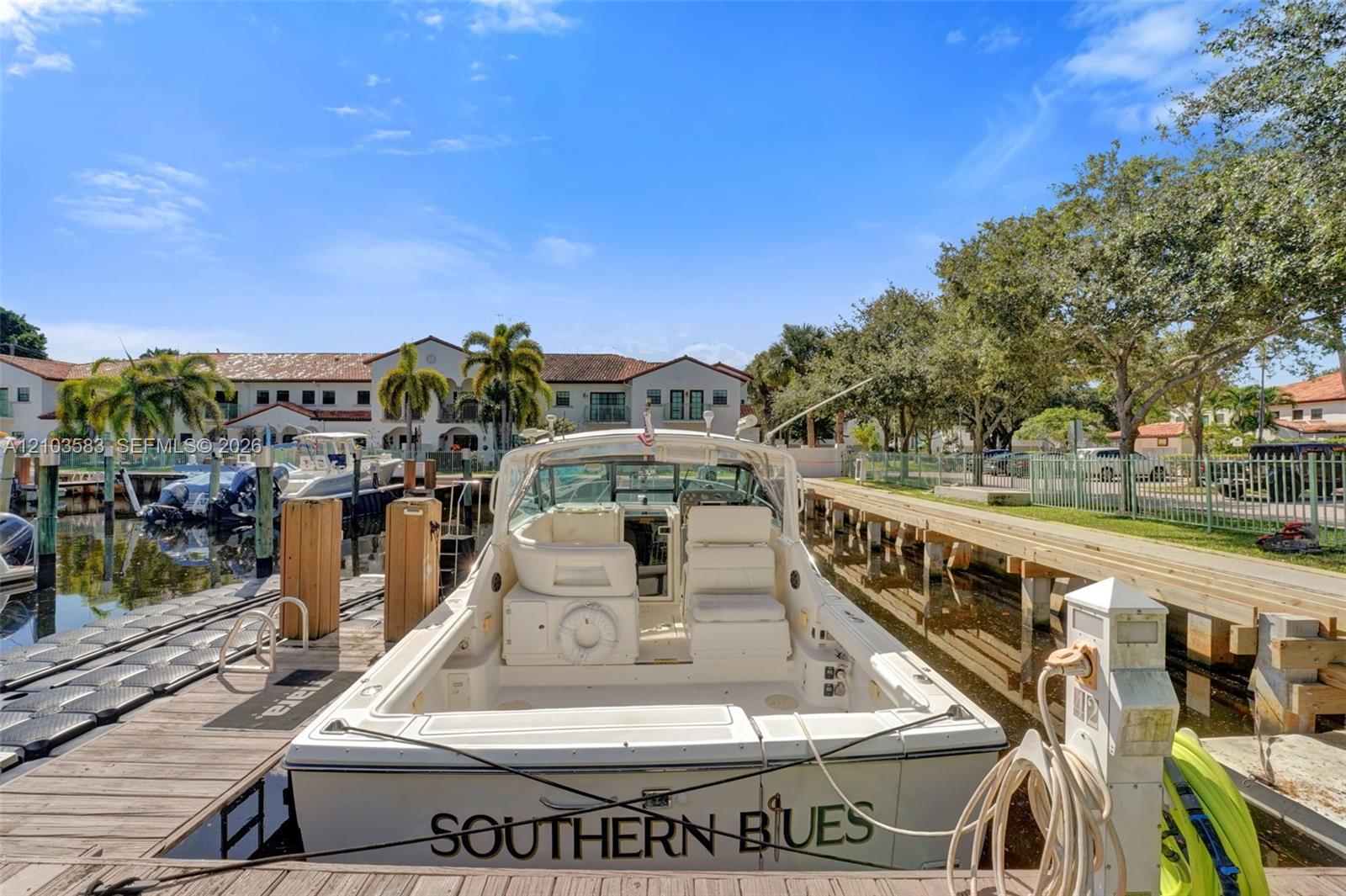 Private deep-water dock with wooden decking, modular floating dock system, and utility pedestals