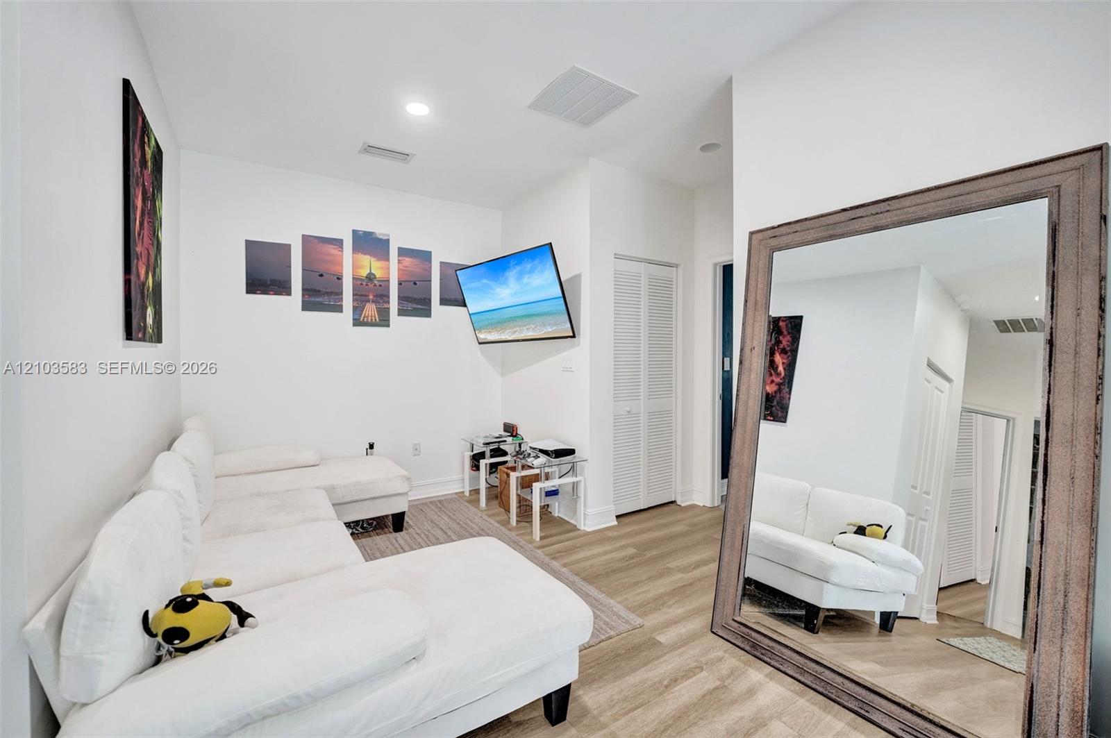 Interior space featuring wood-finish flooring, recessed lighting, and a closet with louvered doors