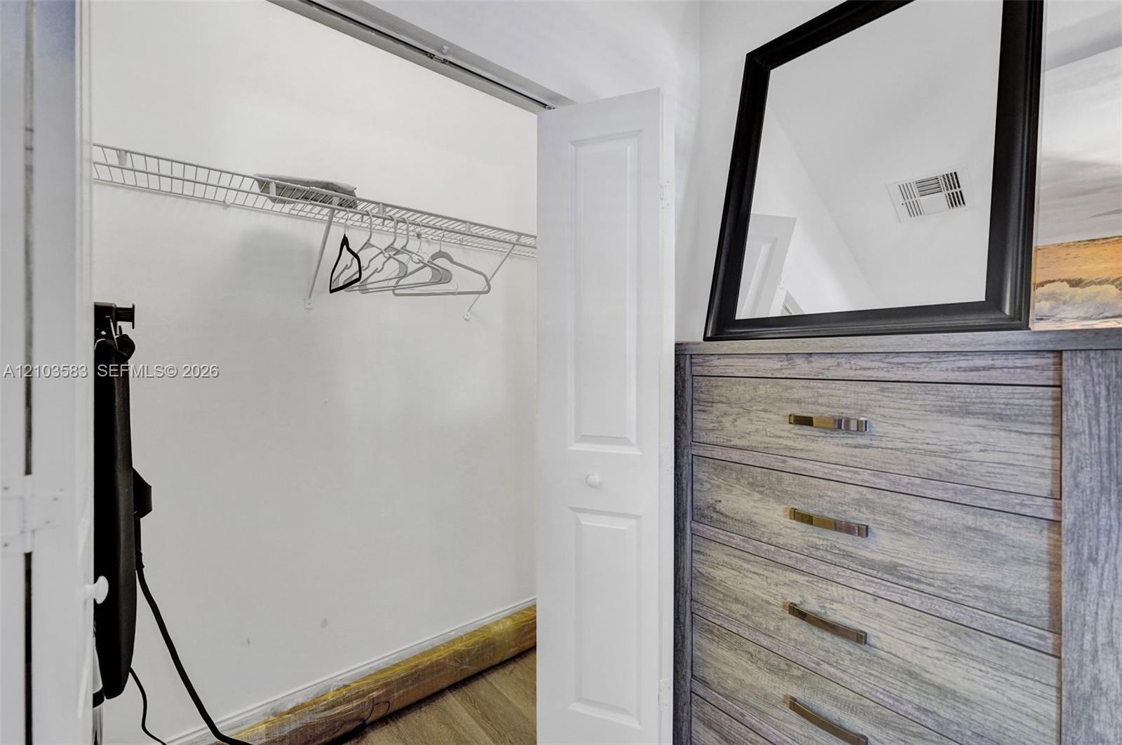 Reach-in closet featuring white bi-fold doors and integrated wire shelving