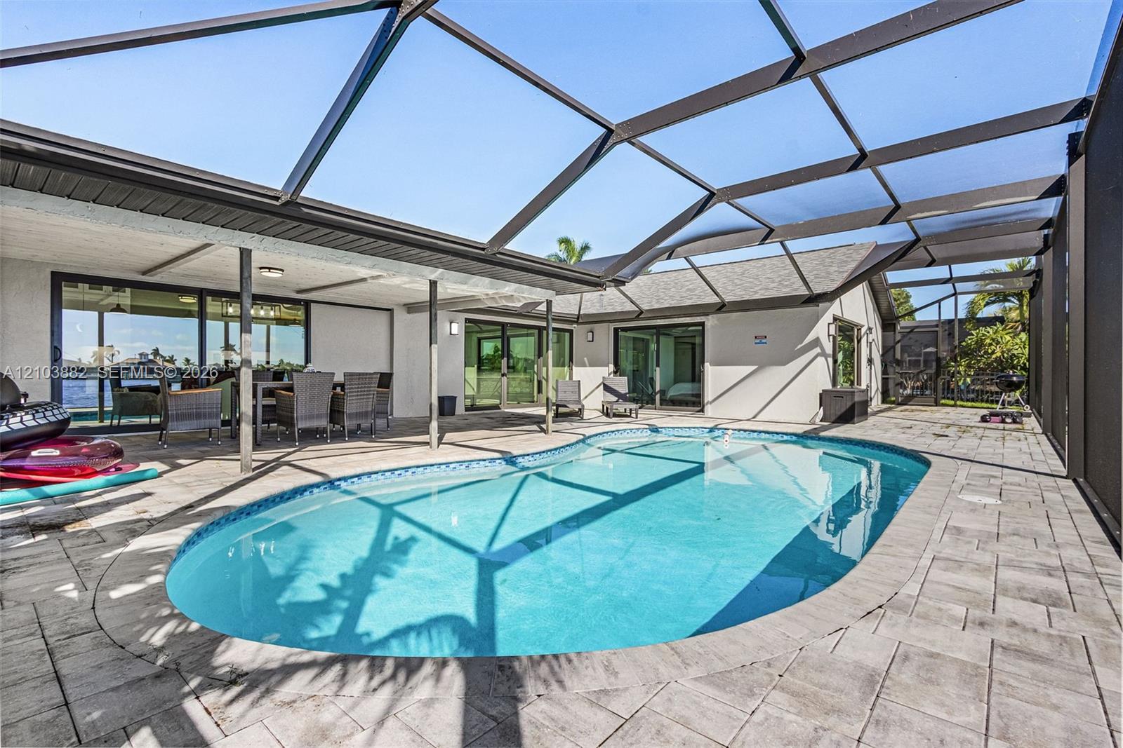 Screen-enclosed swimming pool featuring a paver patio and a covered lanai