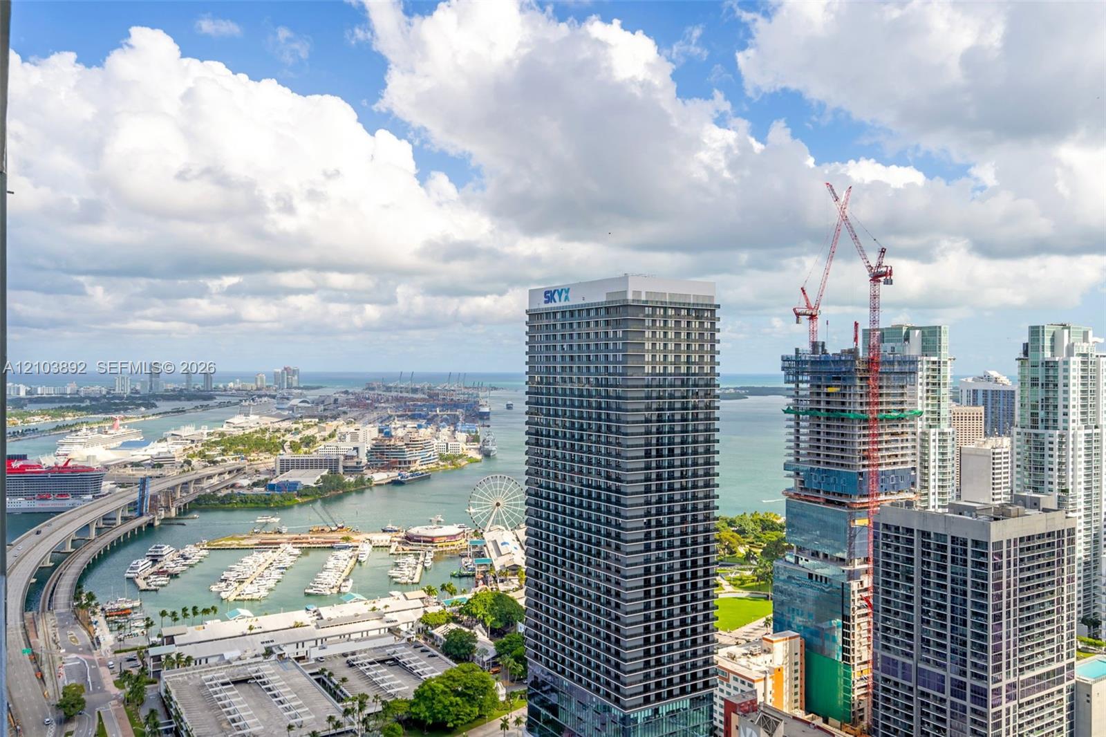Elevated perspective featuring coastal cityscape, deep-water marina, multi-lane infrastructure, and expansive waterfront