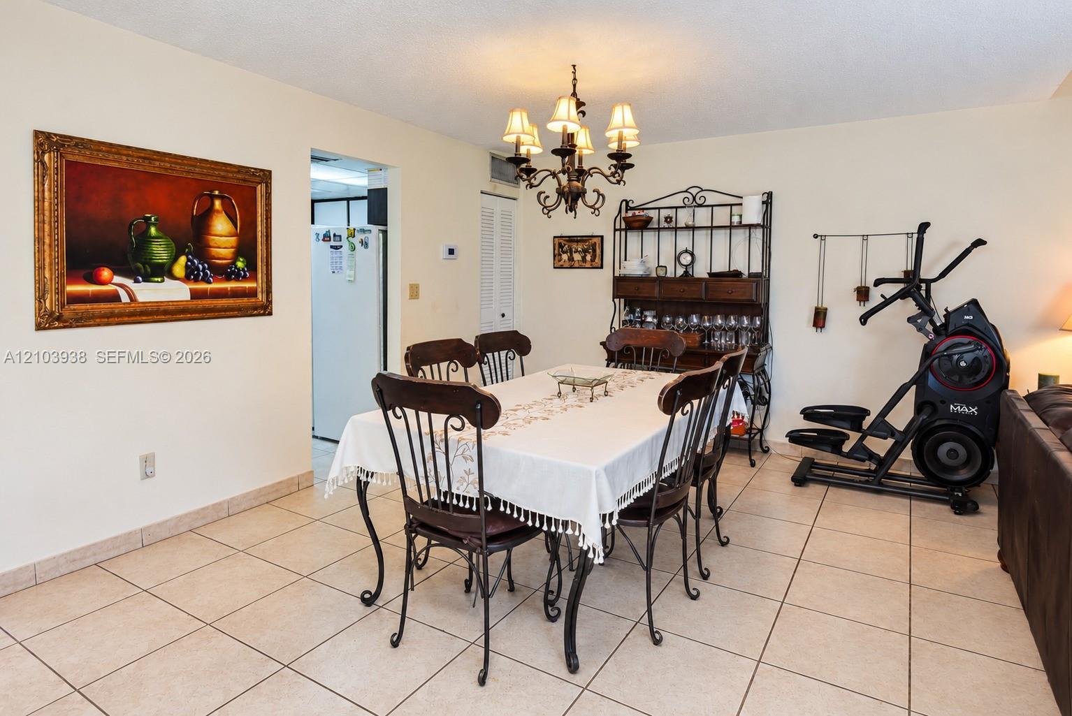 Ceramic tile flooring, crown-style six-arm chandelier, and louvered closet doors
