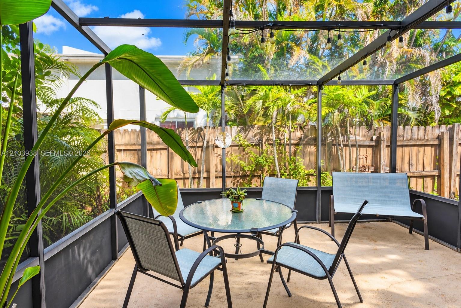 Screened-in patio featuring a concrete floor, metal framing, and a wood privacy fence