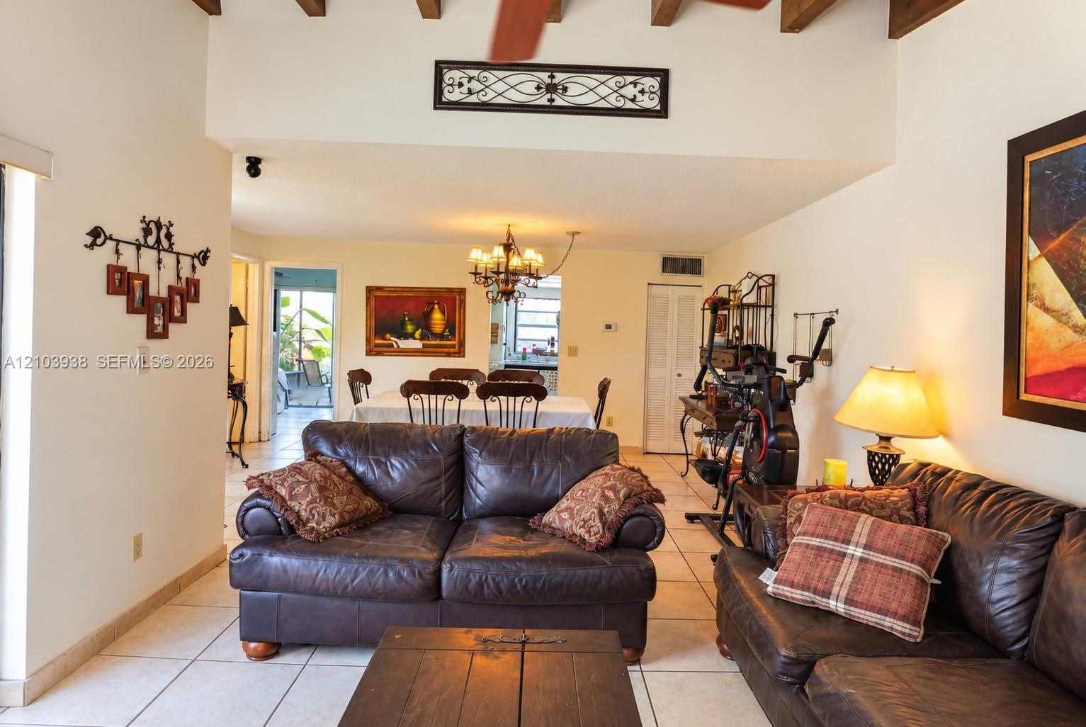 Exposed timber ceiling beams, ceramic tile flooring, and decorative metal wall-mounted accents