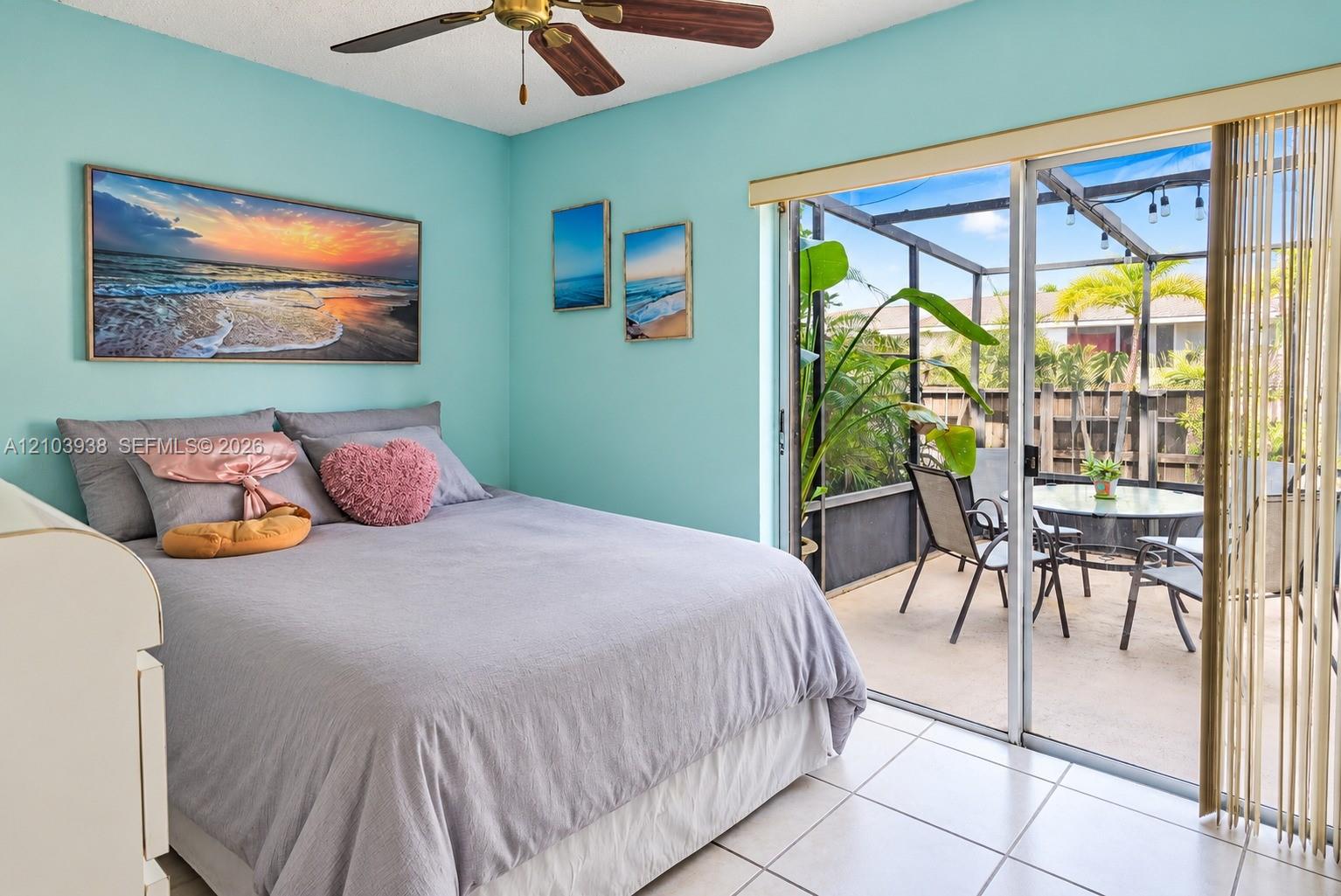Ceramic tile flooring, ceiling fan, and sliding glass doors opening to a screened-in patio