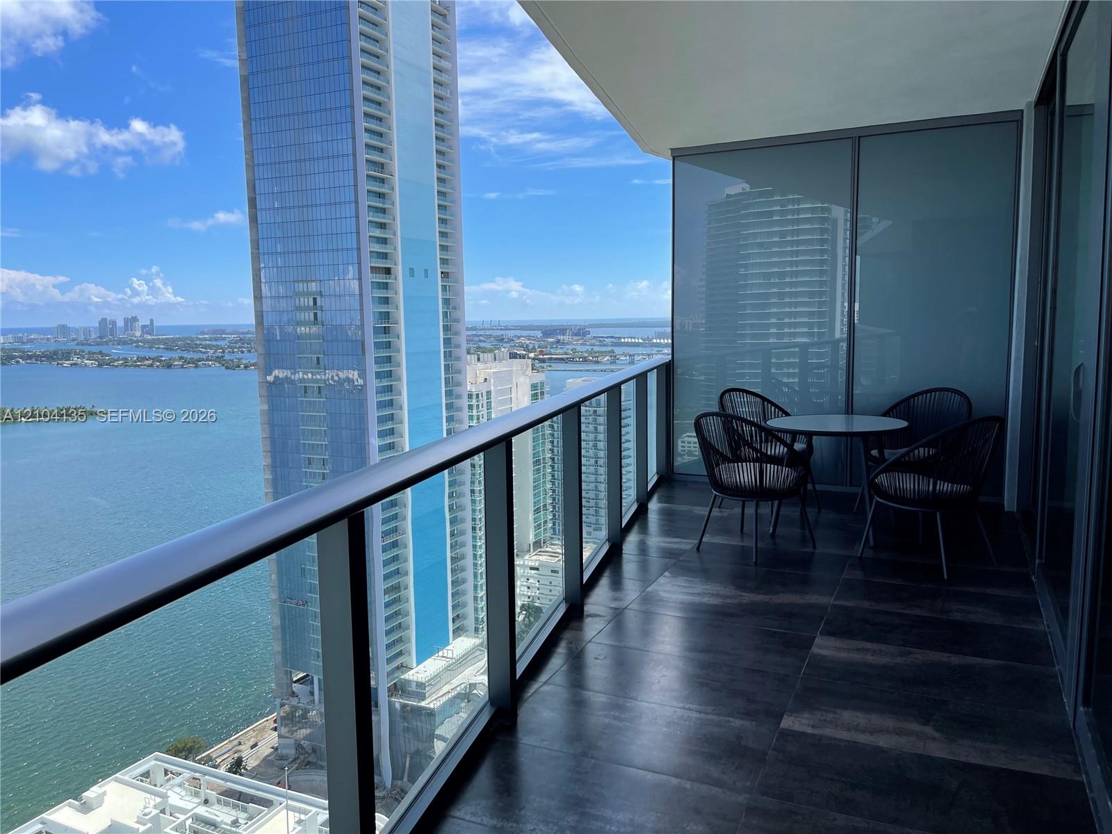 Private balcony featuring large-format tile flooring and a glass panel railing Private balcony featuring large-format tile flooring and a glass panel railing