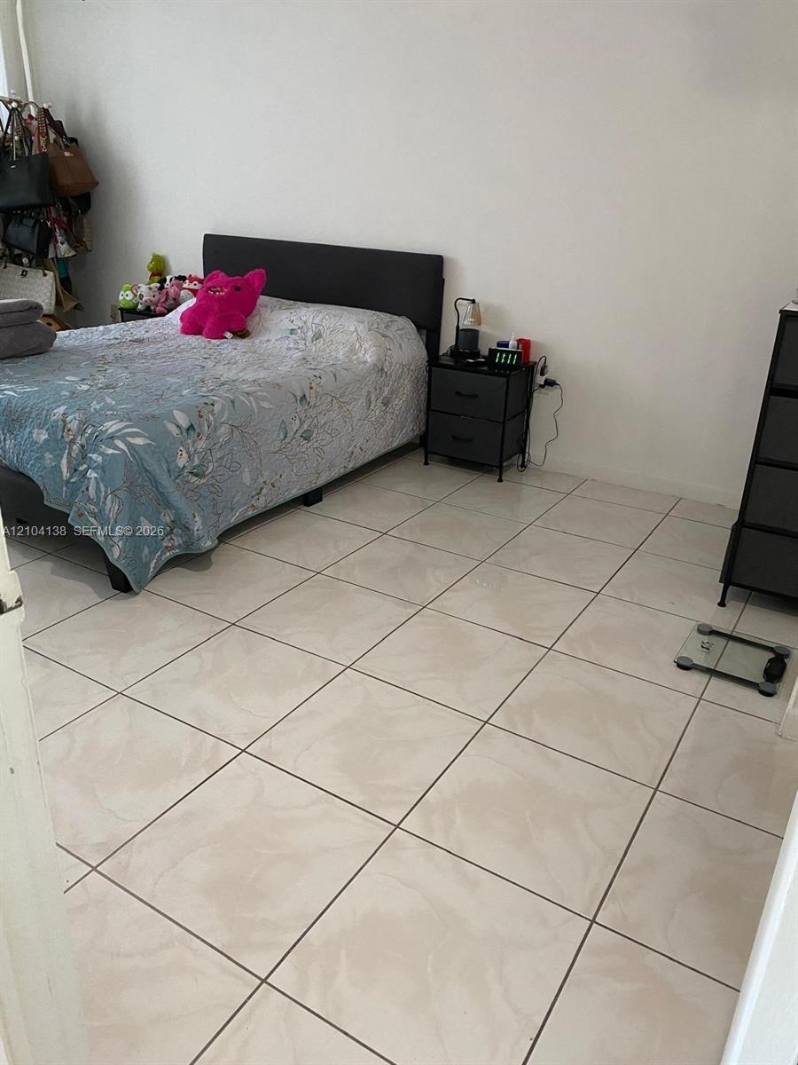 Room featuring large-format ceramic floor tiles and a neutral wall finish