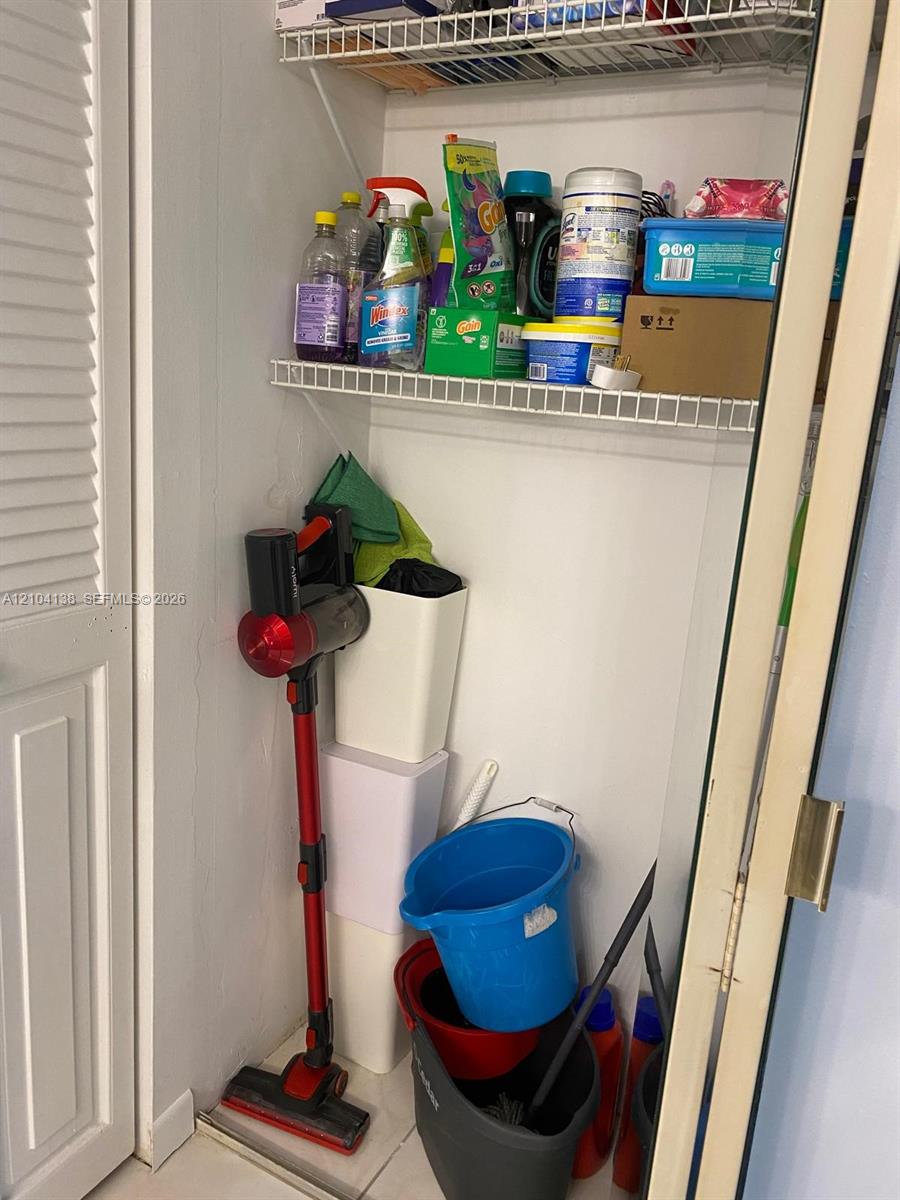 Storage closet featuring white wire shelving and a louvered door