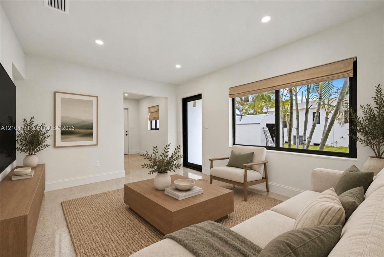 Bright living space featuring neutral wall paint, recessed lighting, large picture windows with black trim, and polished stone-finish flooring