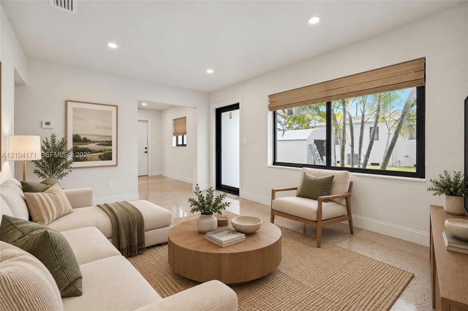 Neutral-toned interior featuring terrazzo flooring, recessed lighting, and large picture windows framed in black