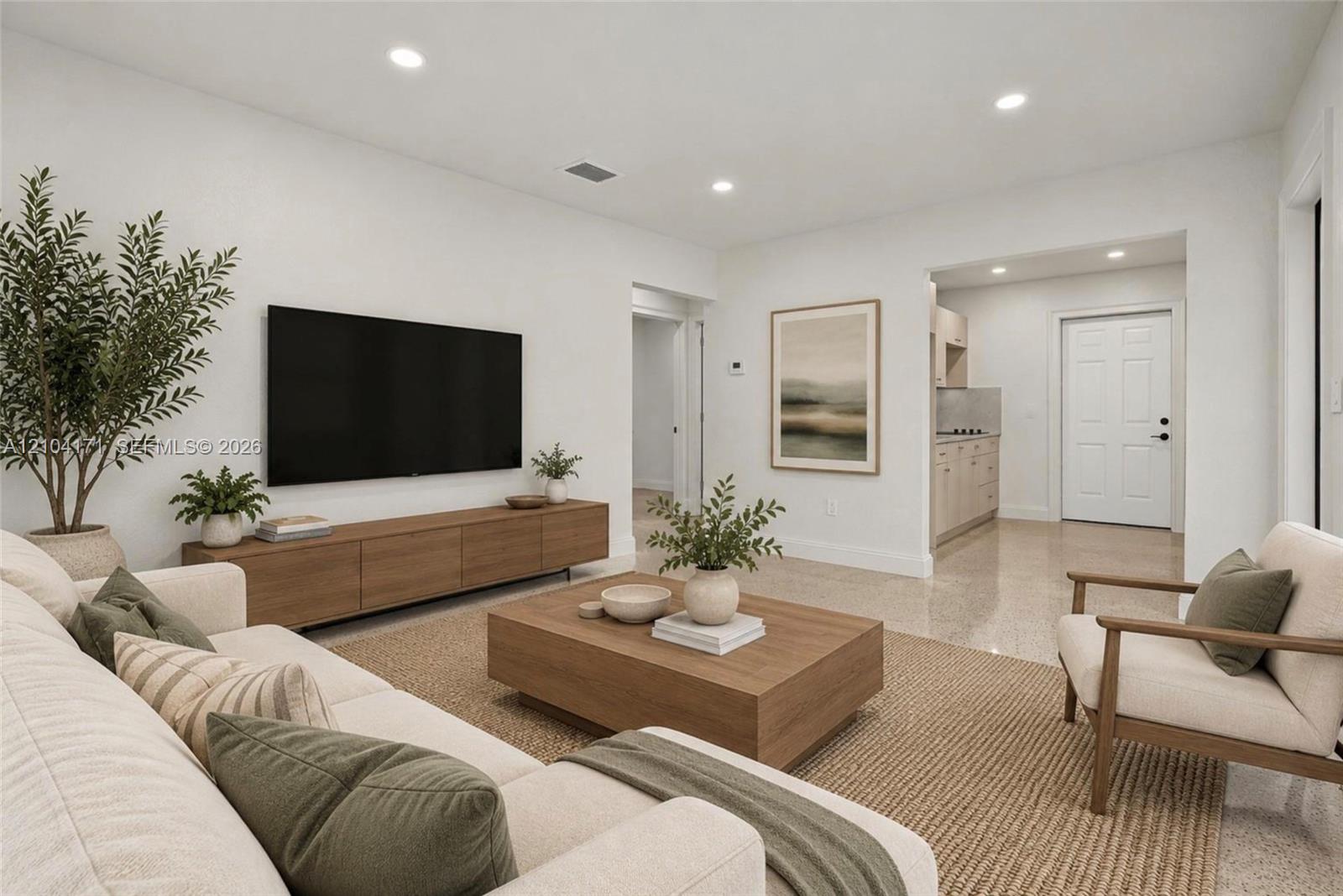 Open floor plan featuring recessed lighting, smooth-finish wall surfaces, polished stone flooring, and a multi-panel door