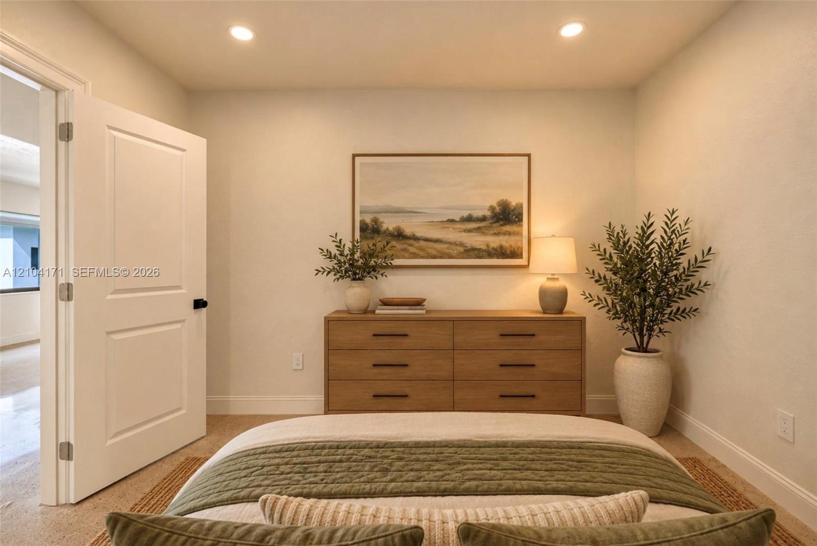 Neutral interior room featuring recessed ceiling lighting, a solid-core panel door, and light-toned wall finishes