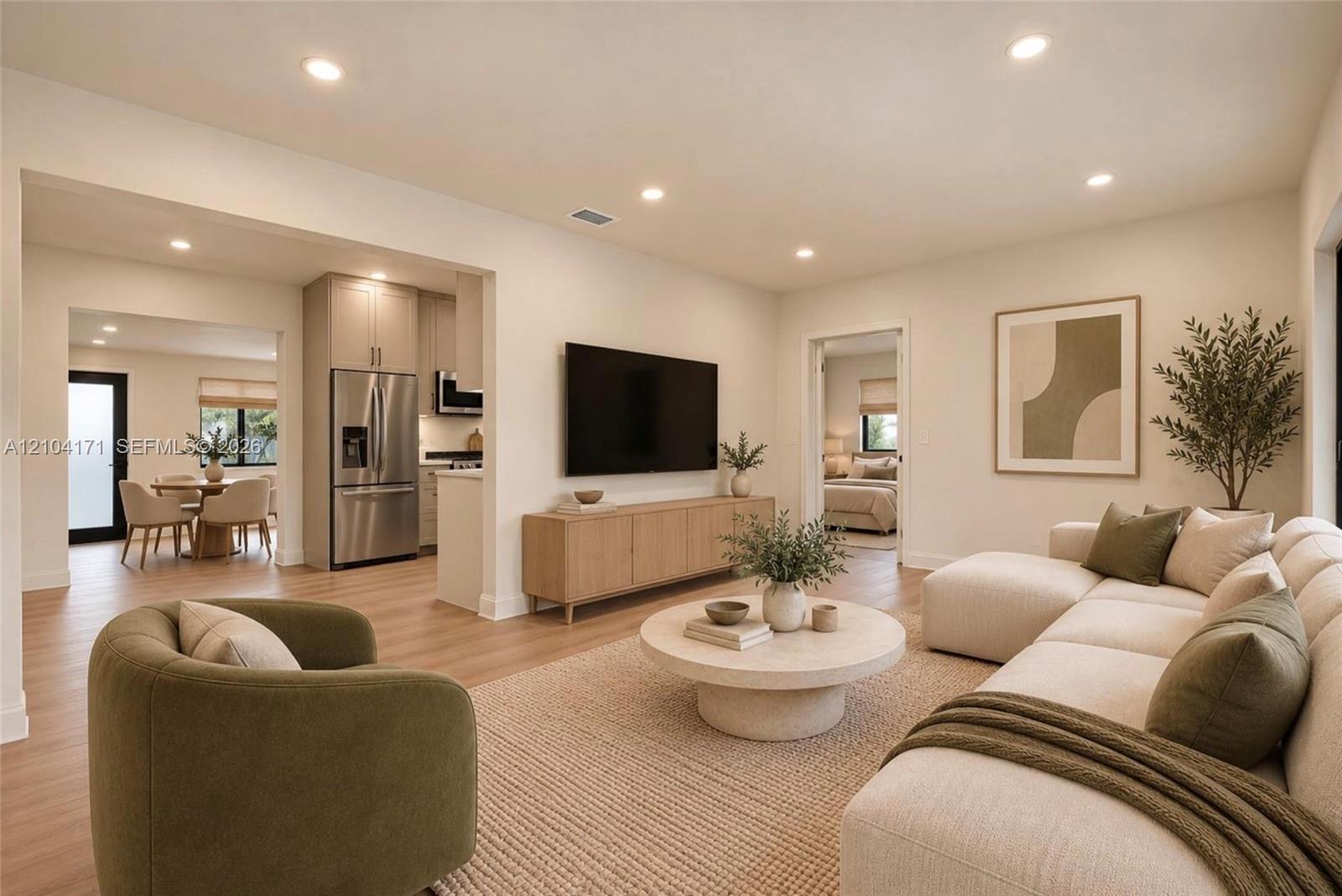Open-concept living space featuring wood-finish flooring, recessed lighting, and stainless steel kitchen appliances