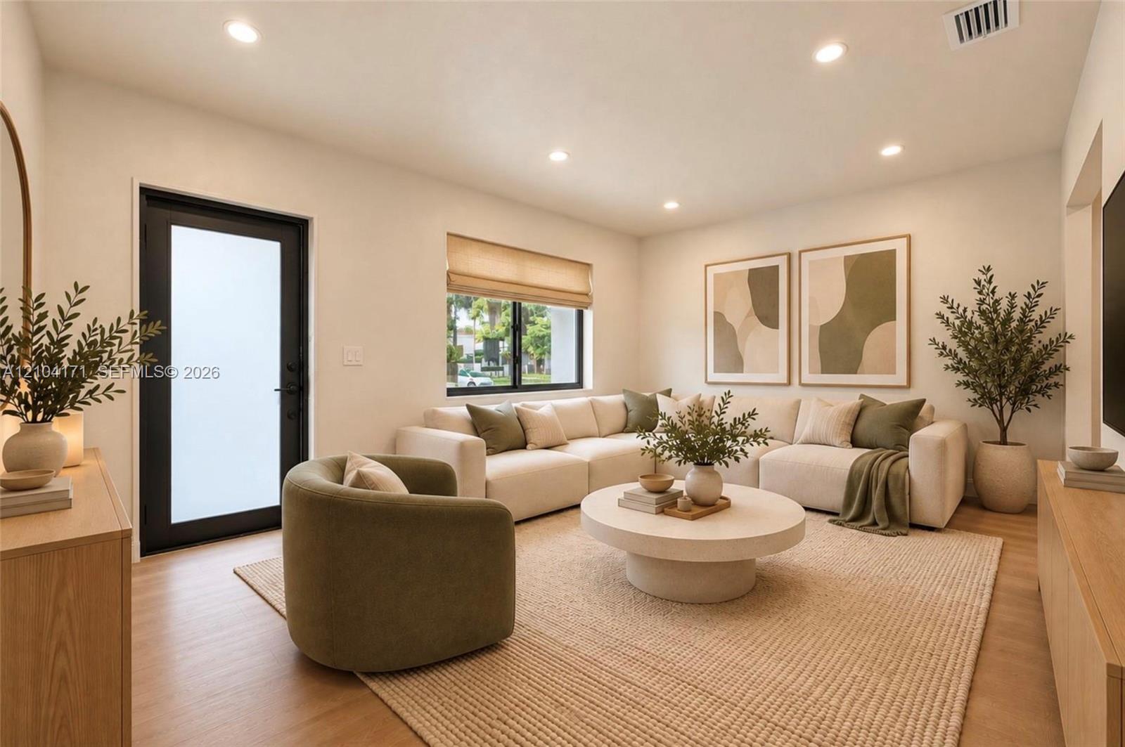 Neutral walls, wood-finish flooring, recessed lighting, and a black-framed exterior door with frosted glass