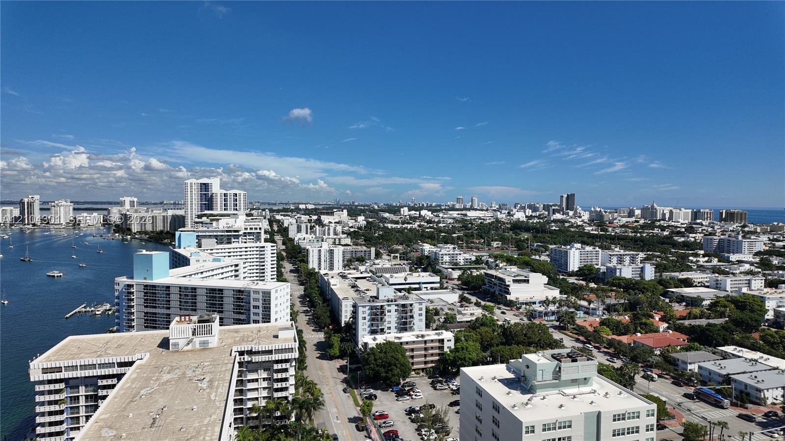 Aerial perspective featuring panoramic urban skyline, waterfront access, and expansive coastal horizon