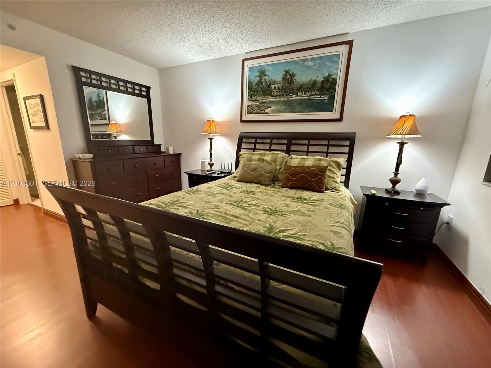 Bedroom featuring wood-finish flooring and neutral wall color Bedroom featuring wood-finish flooring and neutral wall color