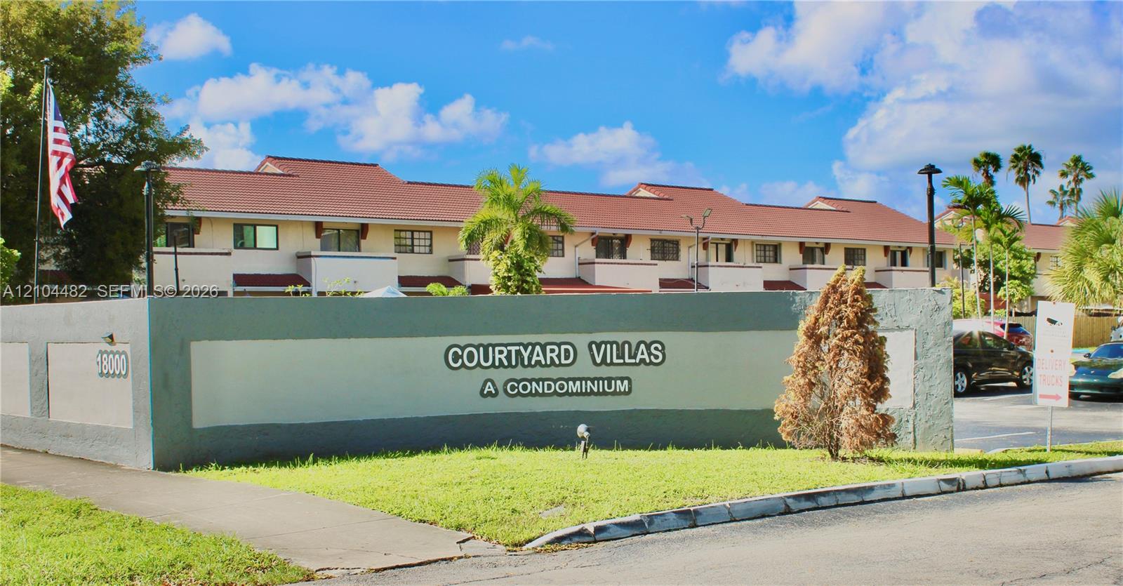 Multi-story condominium exterior featuring a tiled roof, stucco facade, and exterior lighting fixtures Multi-story condominium exterior featuring a tiled roof, stucco facade, and exterior lighting fixtures