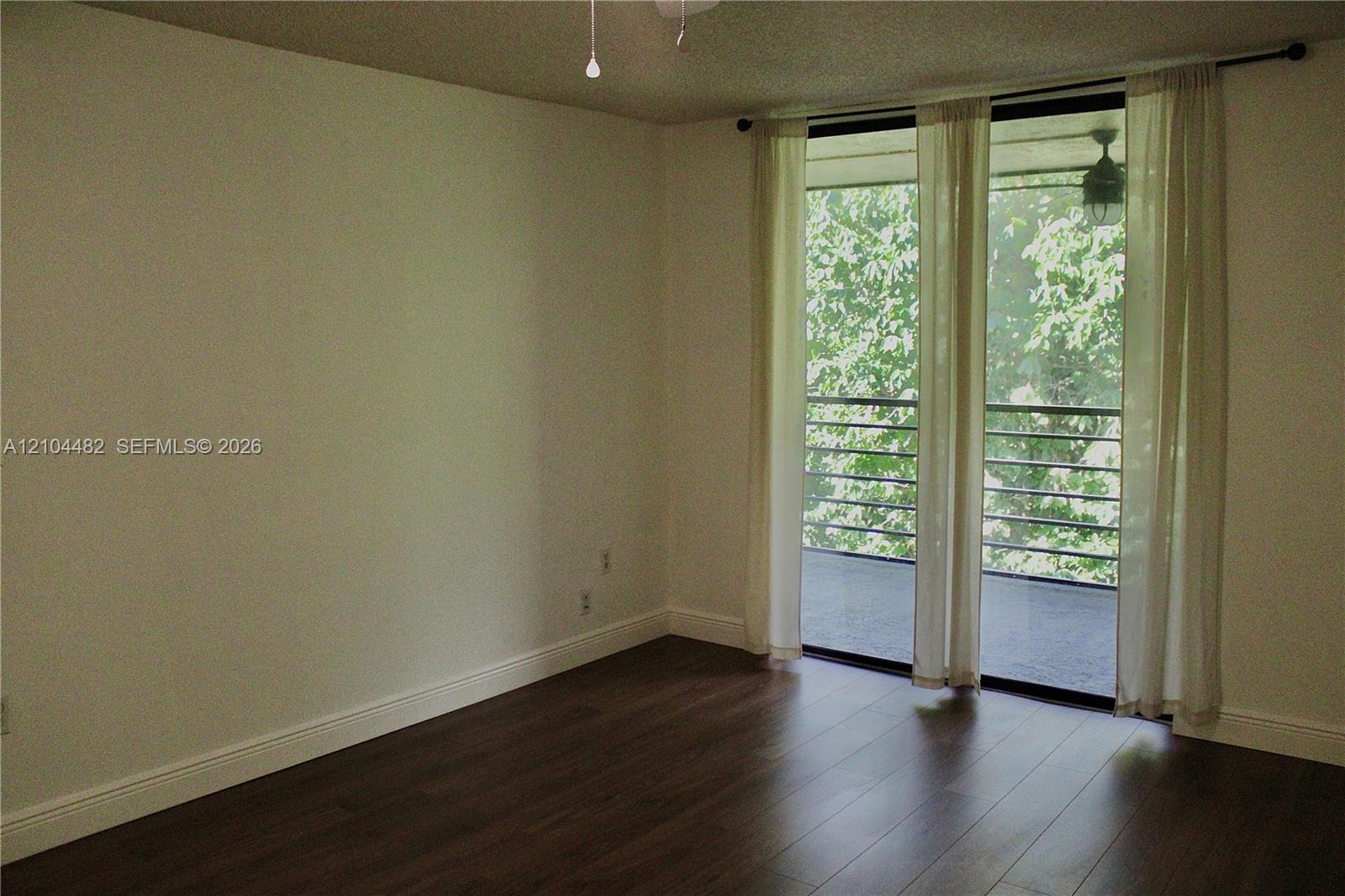 Wood-finish flooring, sliding glass door, and private balcony with metal railing