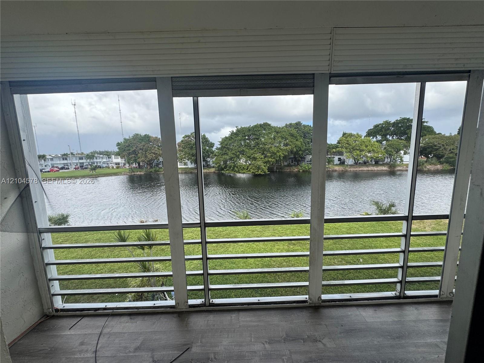 Enclosed patio featuring aluminum framing, wood-finish flooring, and direct water frontage