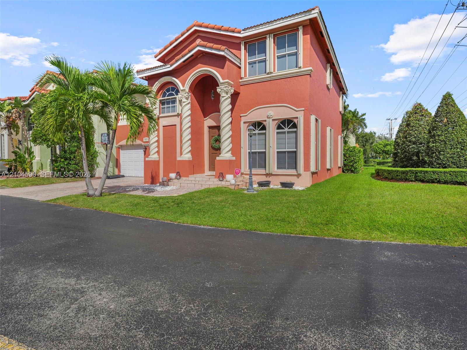 Two-story Mediterranean-style exterior featuring decorative spiral columns, arched window detailing, a tiled roof, and a paved walkway Two-story Mediterranean-style exterior featuring decorative spiral columns, arched window detailing, a tiled roof, and a paved walkway