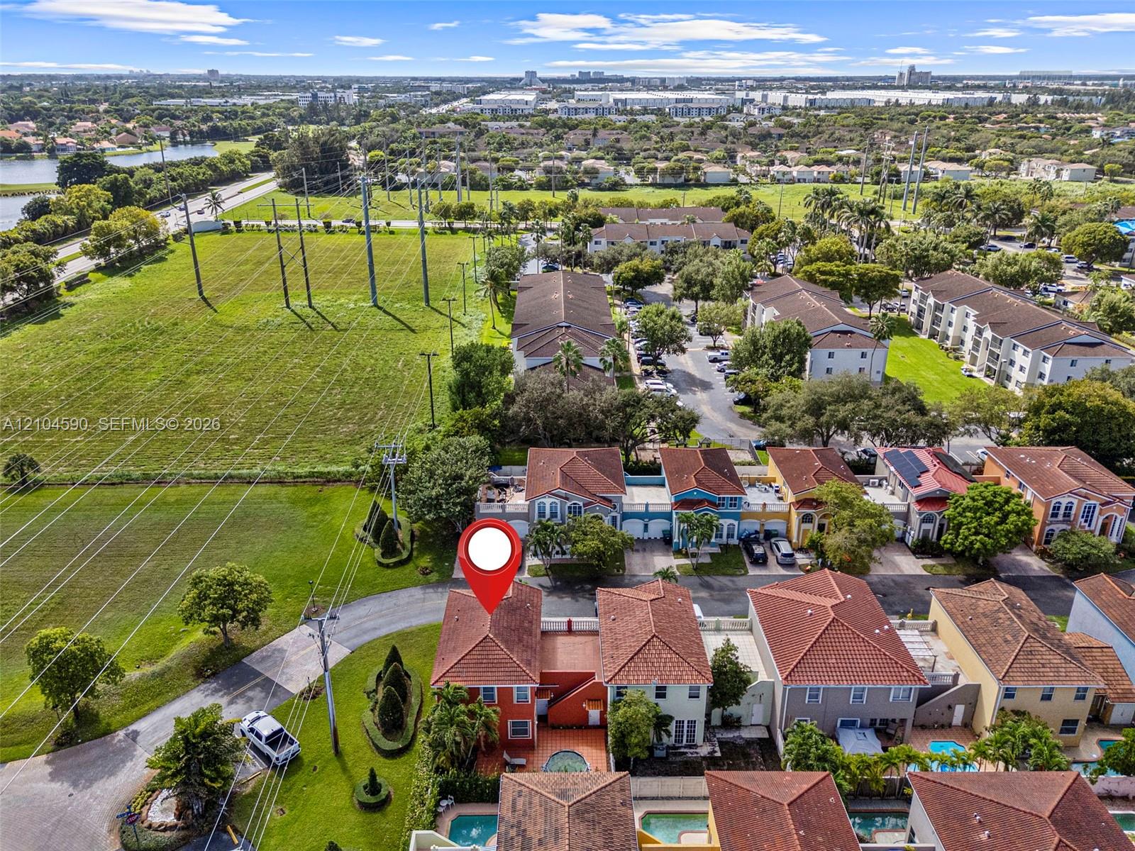 Aerial perspective of a multi-story residence featuring a terracotta tile roof, exterior stucco finish, and a private enclosed courtyard with a swimming pool