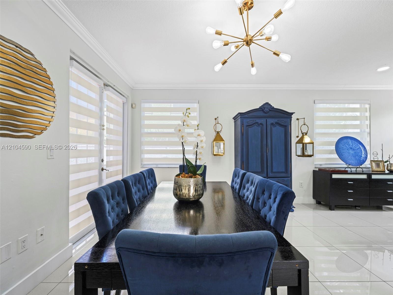 Large-format polished tile flooring, contemporary multi-arm metallic light fixture, and banded roller shades
