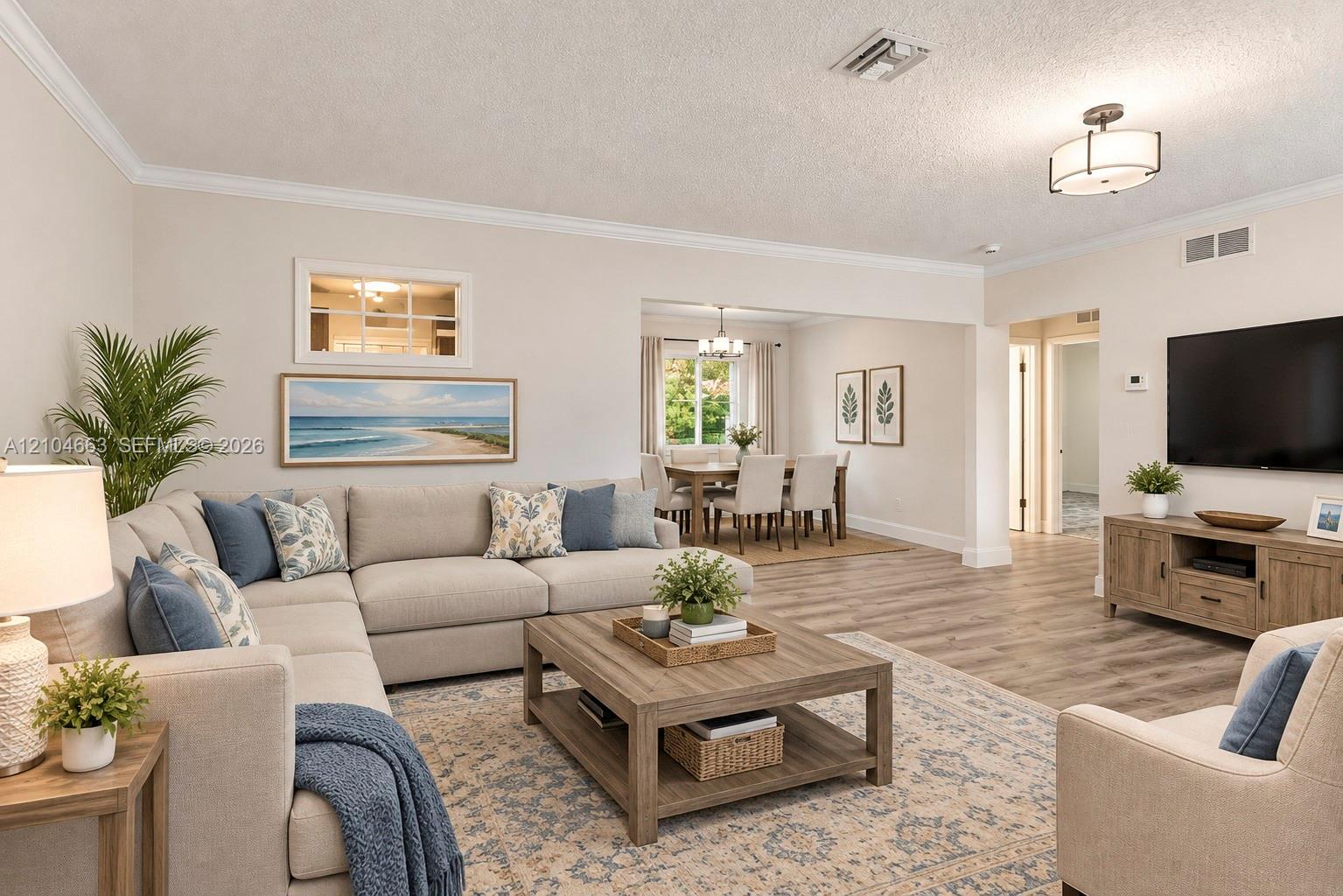 Open-concept living space featuring wood-finish flooring, crown molding, neutral wall color, and a semi-flush mount light fixture Open-concept living space featuring wood-finish flooring, crown molding, neutral wall color, and a semi-flush mount light fixture